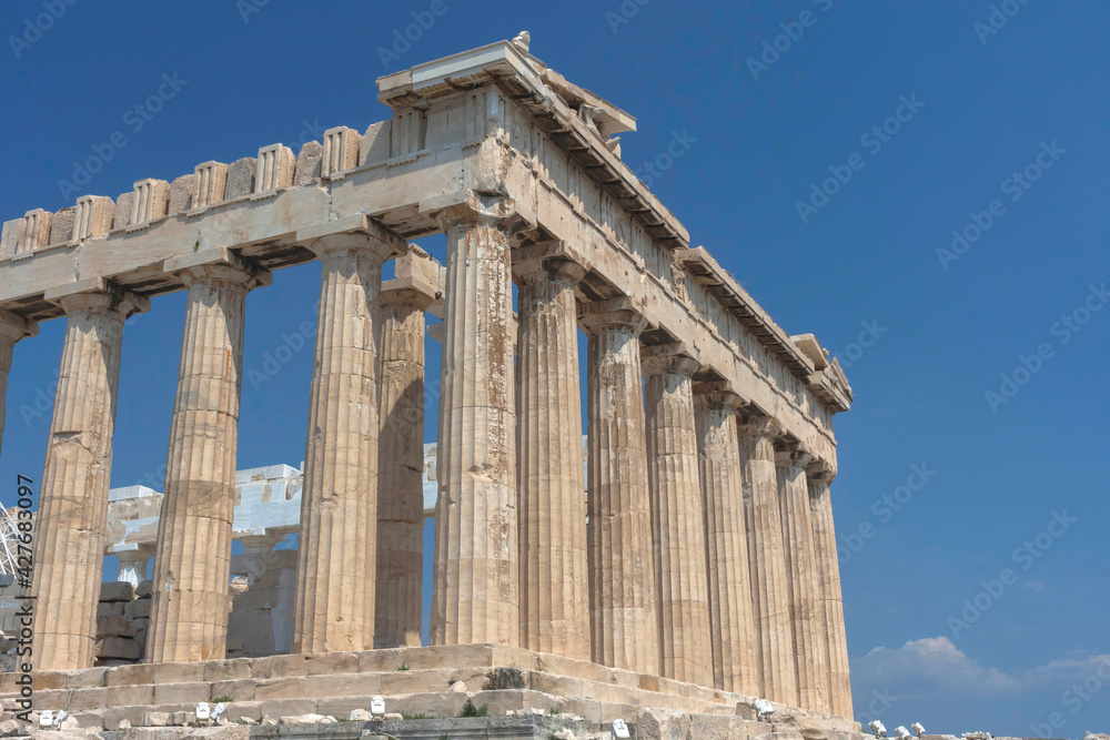 The ancient Parthenon temple on Acropolis hill, famous landmark and tourist attraction in Athens, Greece, in sunny summer day The ancient Parthenon temple on Acropolis hill, famous landmark and tourist attraction in Athens, Greece, in sunny summer day