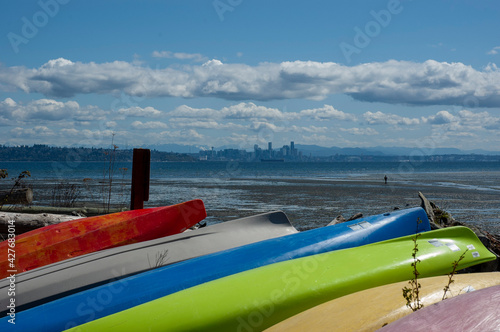 Manitou beach at low tide, with skyline of Seattle in the background and kayaks in the front