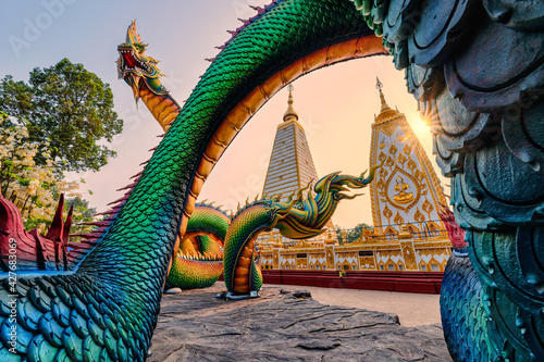 Rainbow carve serpent or colorful Thai Naga surrounding Sri Maha Pho Chedi stupa in the sunset at Wat Phra That Nong Bua