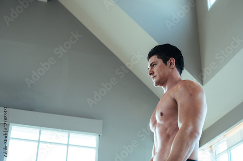 Portrait side view of Caucasian muscular topless man in fitness studio. bodybuilding and healthy body. copy space