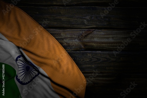 wonderful any holiday flag 3d illustration. - dark illustration of India flag with big folds on old wood with empty place for your text