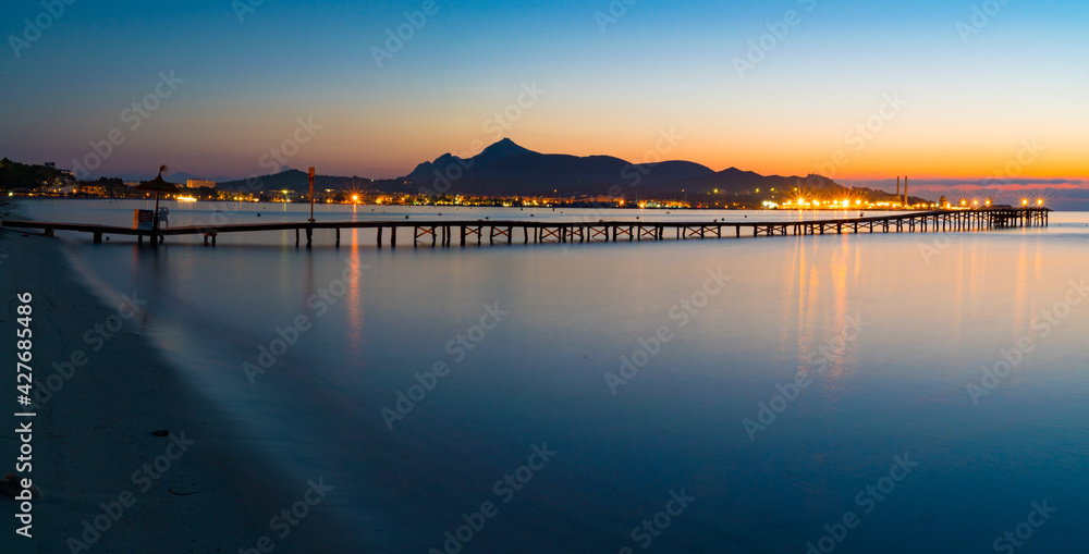 Panorama of a wooden pier on the seashore during sunset