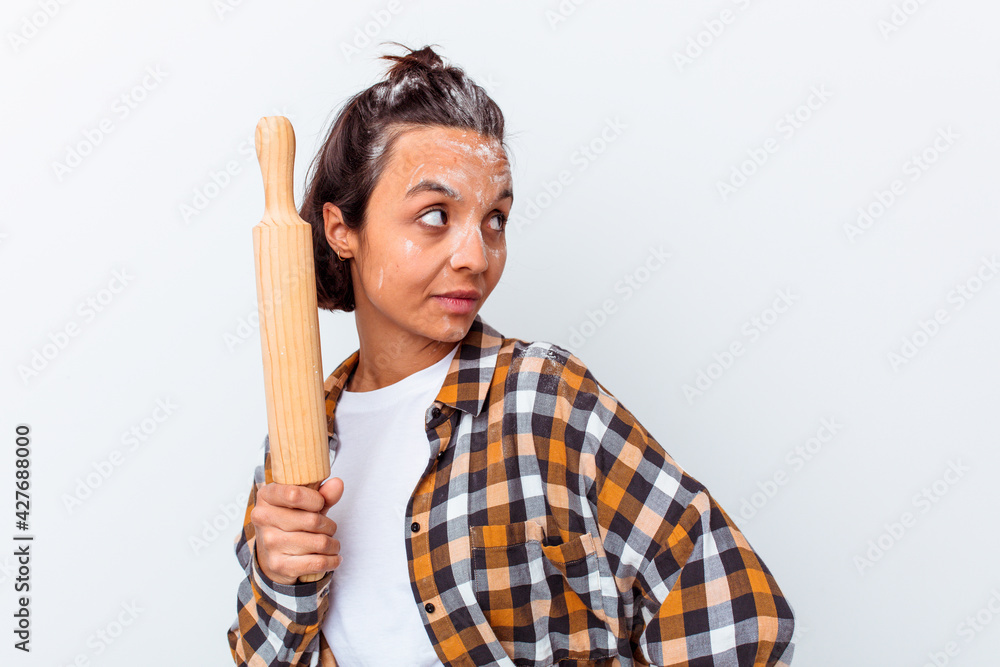 Young mixed race woman making bread isolated on white background looks aside smiling, cheerful and pleasant. Young mixed race woman making bread isolated on white background looks aside smiling, cheerful and pleasant.