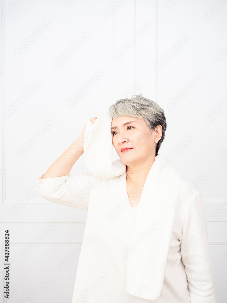 Active mature female refreshing and wipe sweat during workout. Active mature female refreshing and wipe sweat during workout.