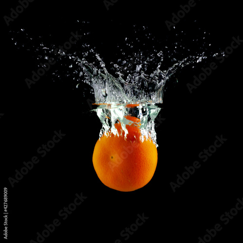 tangerine in water on a black background, place under the text