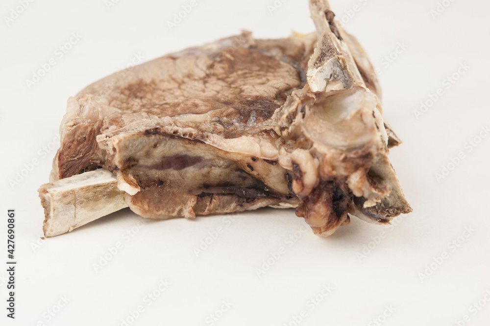 Piece of boiled beef with bone on white background Piece of boiled beef with bone on white background