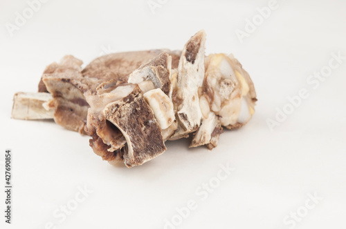 Piece of boiled beef with bone on white background