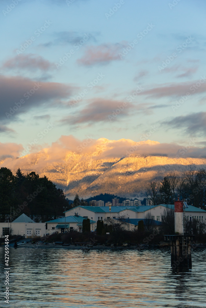 sunset over the harbour with snowy mountains in the background