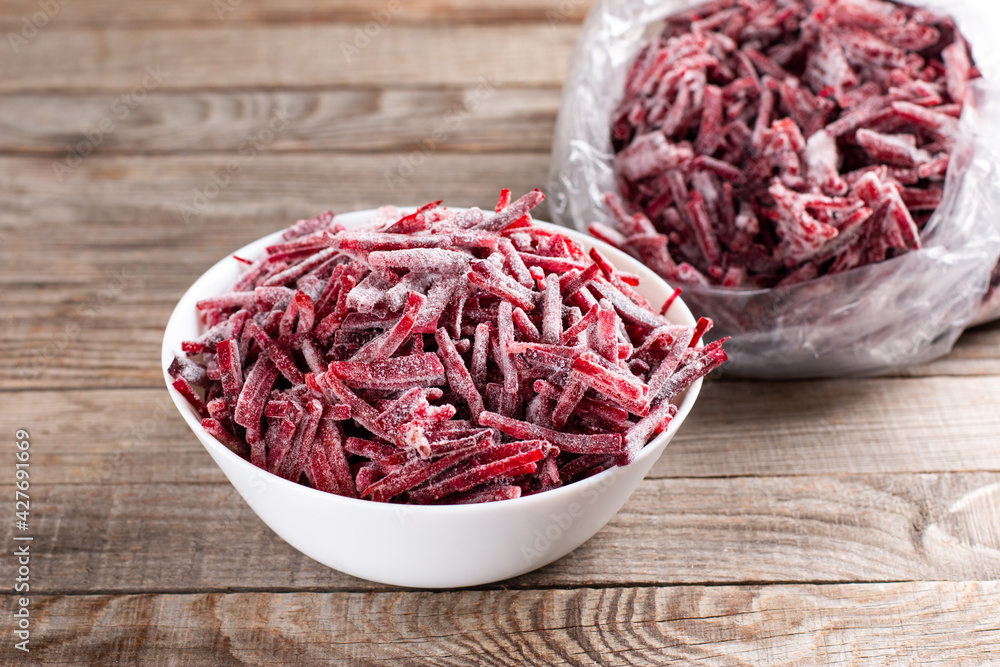 Frozen beet in a white plate on a table. Frozen food, frozen vegetables. Frozen beet in a white plate on a table. Frozen food, frozen vegetables.