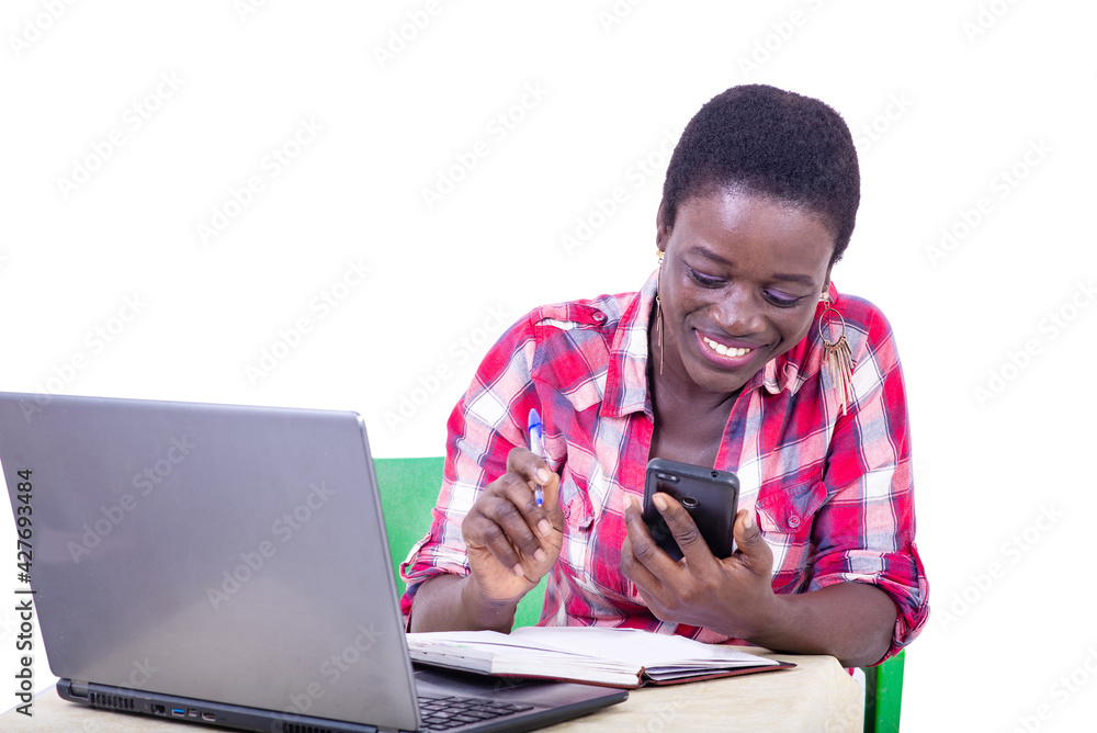 young businesswoman taking notes in the textbook using a mobile young businesswoman taking notes in the textbook using a mobile