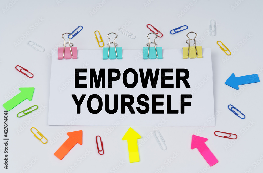 On the table there are paper clips and directional arrows, a sign that says - EMPOWER YOURSELF On the table there are paper clips and directional arrows, a sign that says - EMPOWER YOURSELF