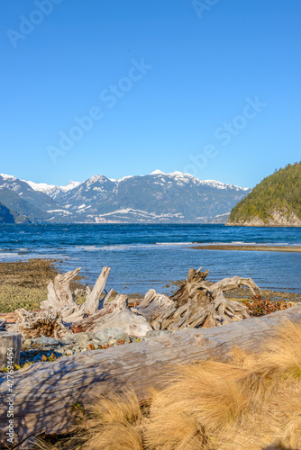 Fantastic view over ocean, snow mountain and rocks at Furry Creek Dive Site in Vancouver, Canada.