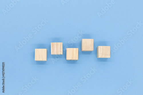 Square wooden blocks on white and blue background 