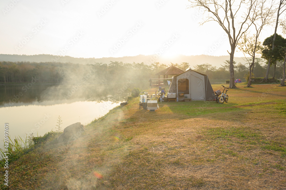 Fototapeta premium Camping Tent near river in the morning, traveling and holidays concept