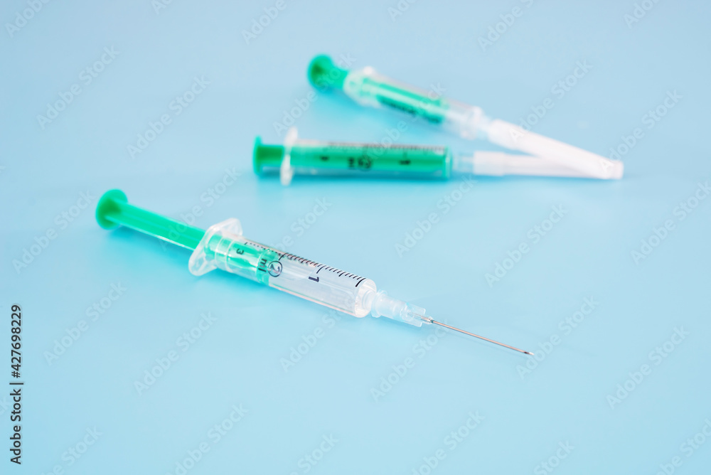 Syringes with a vaccine on a blue background. Syringes with a vaccine on a blue background.