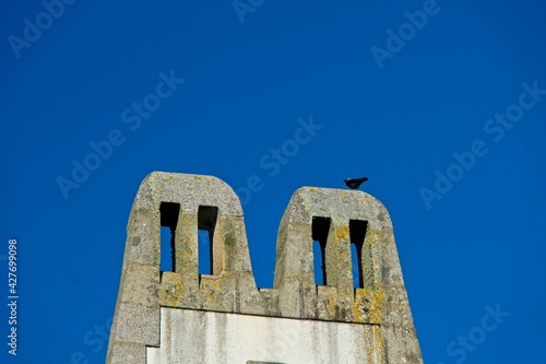 Bird sitting on chimney of old railway station of Plomodiern in Bretagne France photo