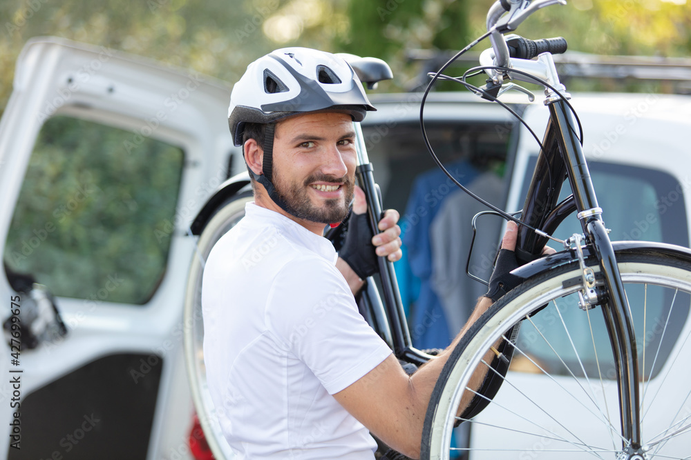 male cyclist putting bikes in car male cyclist putting bikes in car