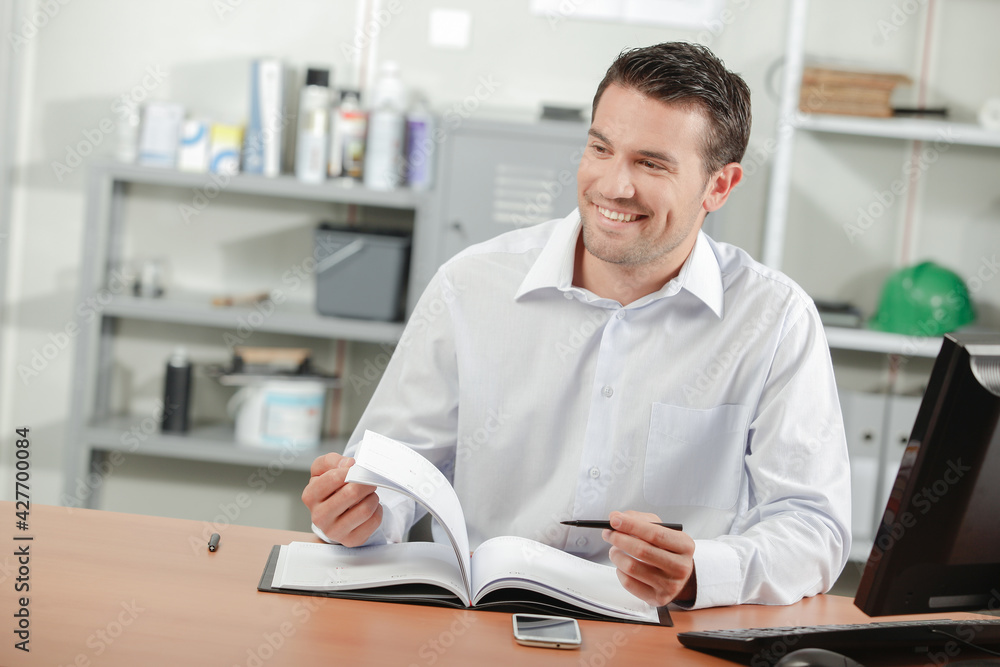 Man sat at desk turning pages of a notebook Man sat at desk turning pages of a notebook