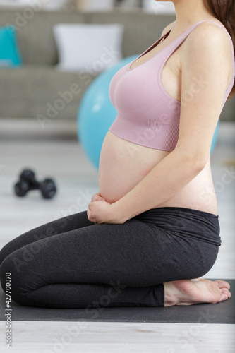 pregnant woman kneeling to meditate