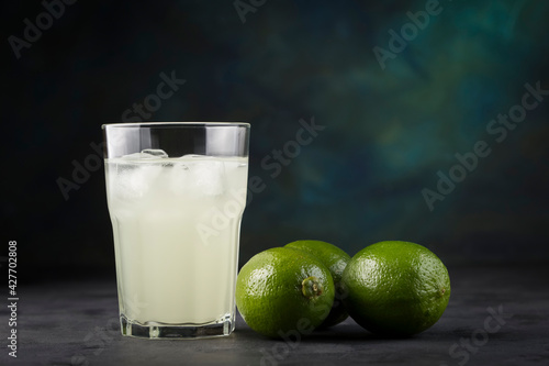 Glass of lemon juice and fruits beside