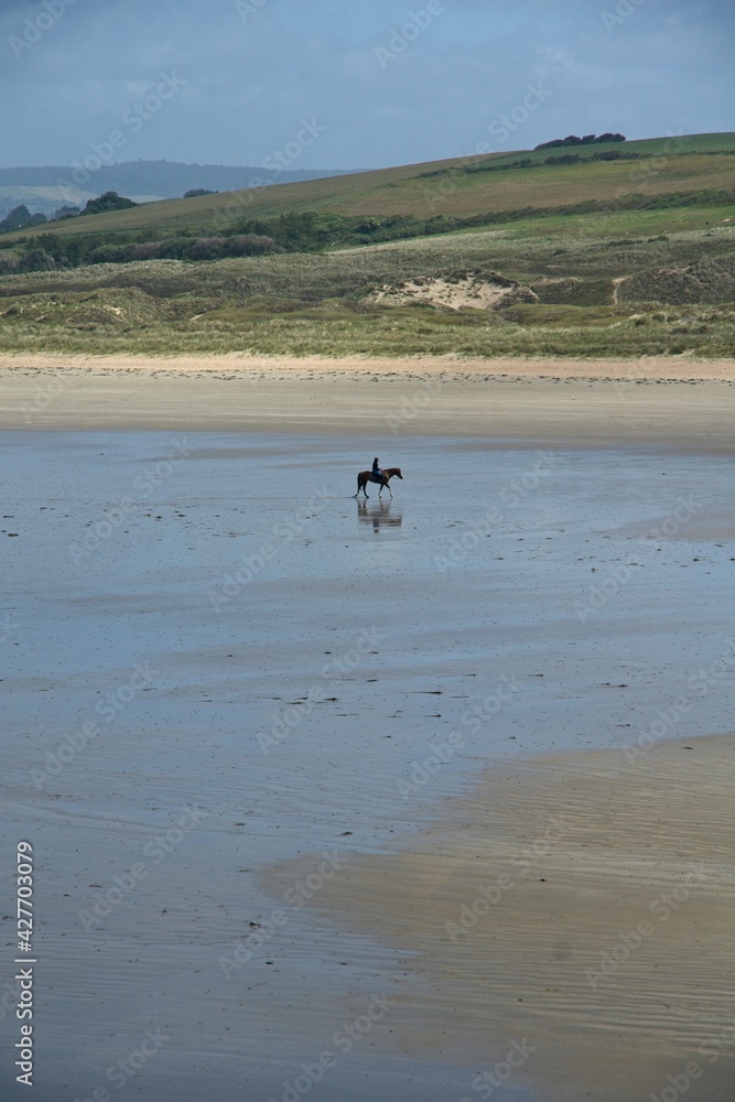Horse back riding on beach of Plovenez-Porzay in Bretagne France