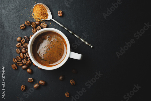 Steaming espresso served in cup on dark