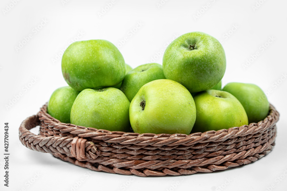 Group of ripe green apples in a basket on white background Group of ripe green apples in a basket on white background
