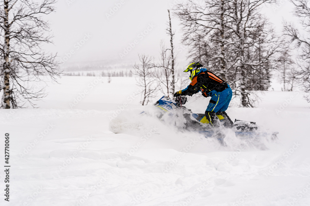 Mountain snowmobile riders ride on the slopes