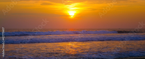 Beautiful sunrise over the tropical beach. Wide photo.