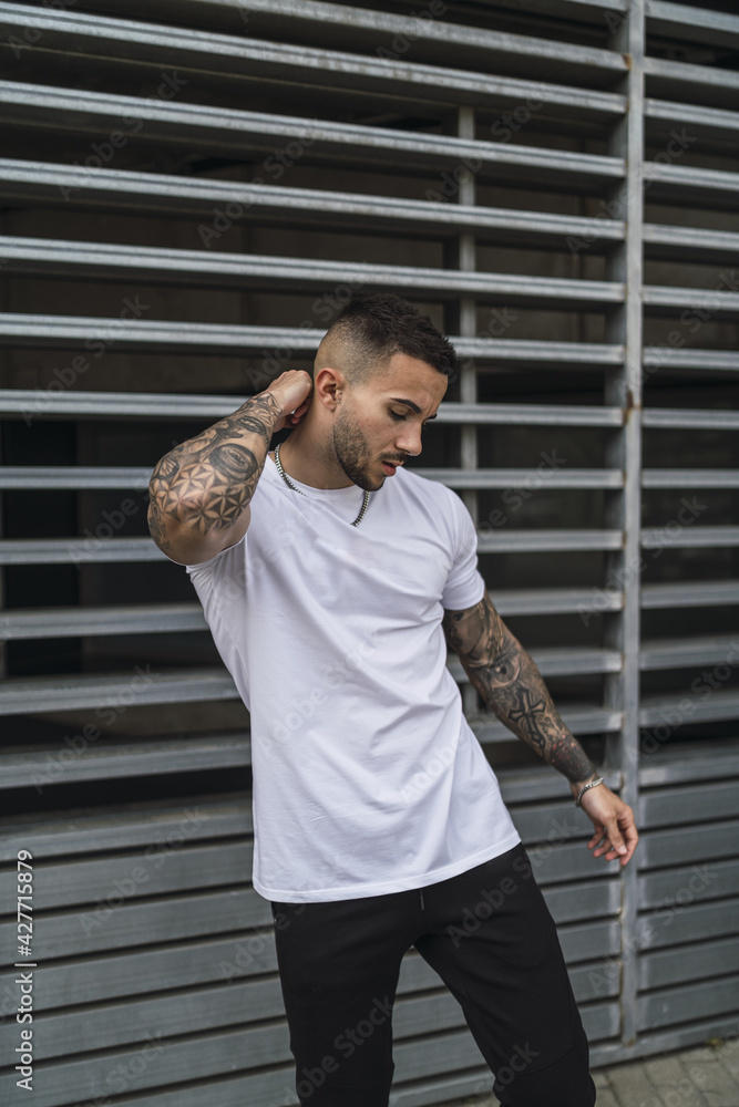 Vertical shot of a sexy male with tattoos posing outdoors Stock Photo |  Adobe Stock