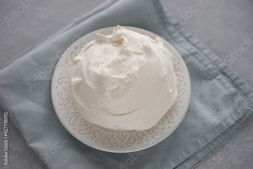 Large meringue on a plate and a blue napkin