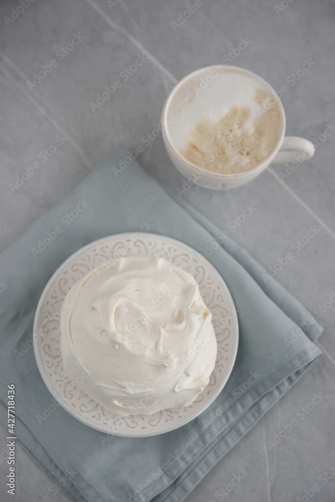 Large meringue on a plate and a blue napkin Large meringue on a plate and a blue napkin