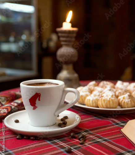 Stilllife with a Cup of coffee, cookies and a book. The atmosphere of a cozy interior Breakfast at home or in a cafe. cappuccino . latte. flowers on the wood table. candle