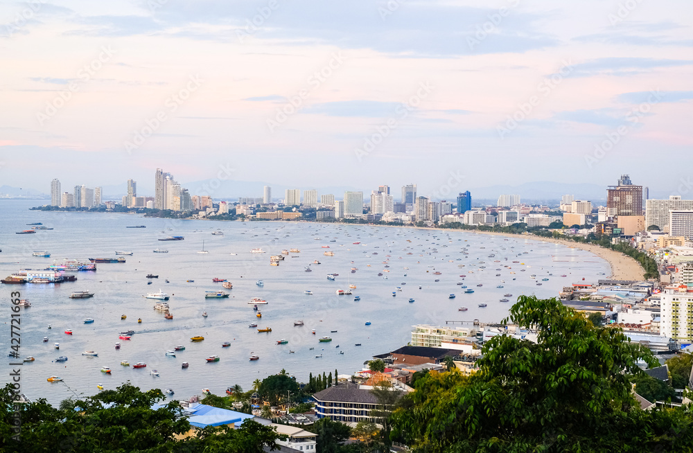 Panoramic view of the city and the bay with boats and yachts at sunset. Pattaya city and the sea at dusk, Thailand.