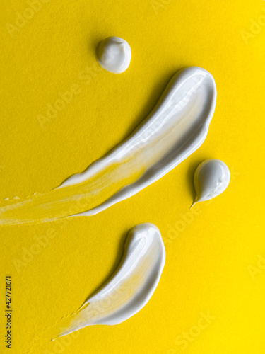 Swabs of creamy textures. Strokes of body lotion or hand cream in different size. Smear of skincare cosmetics product. Cosmetology wellness and beauty concept. Isolated on yellow