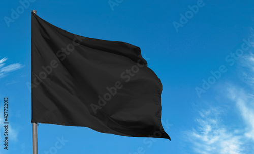 Fényképezés Blank fabric black flag, mourning flag against blue sky