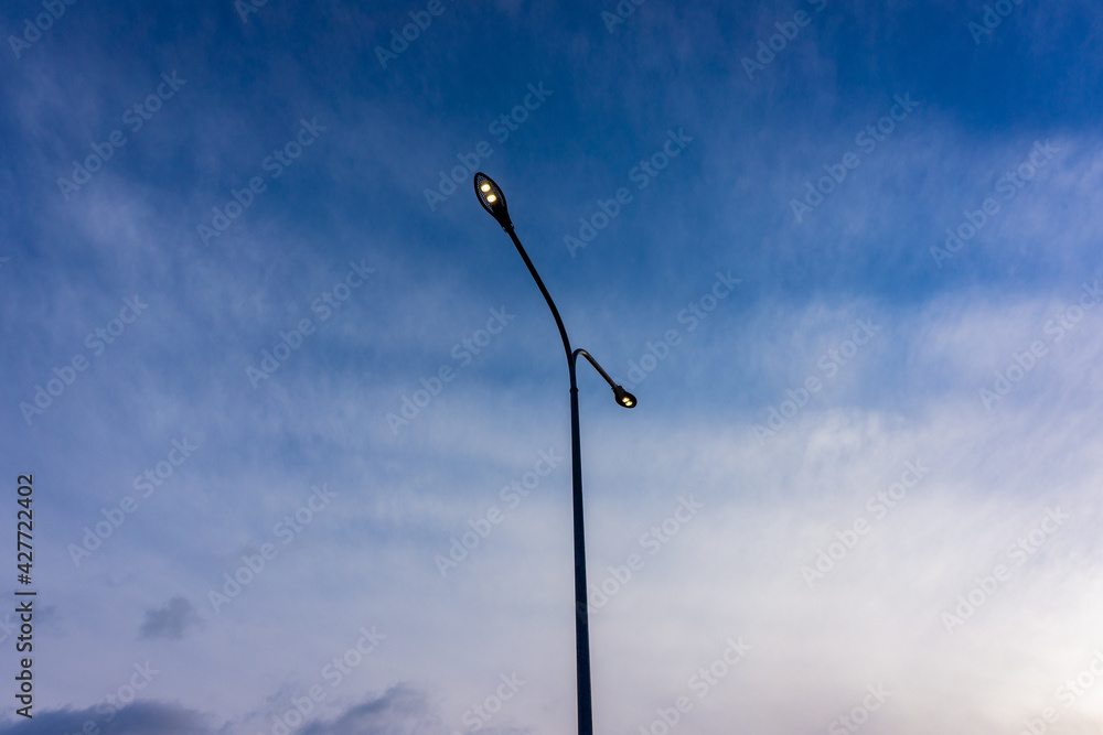 LED lighting of street lamps against the blue sky.
