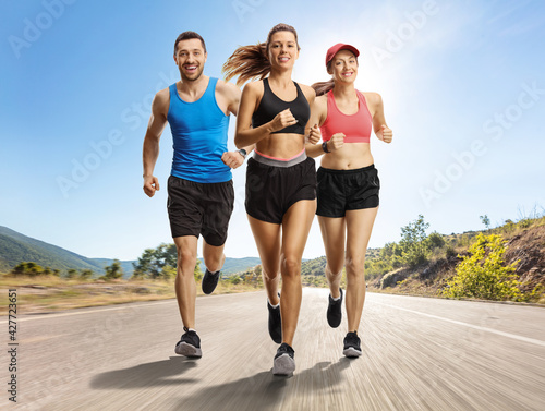 Young sporty people running on an open road