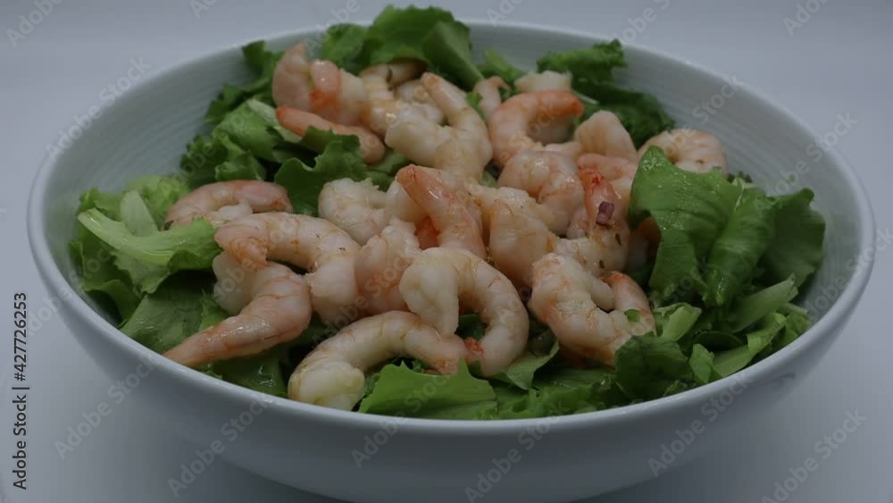 Fresh shrimp salad with lettuce on white dish rotating.
Fresh shrimp salad with lettuce on white dish rotating.