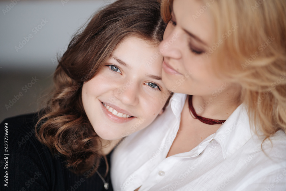 Beautiful mother and her pretty daughter teenager smiling and posing at home. Beautiful mother and her pretty daughter teenager smiling and posing at home.
