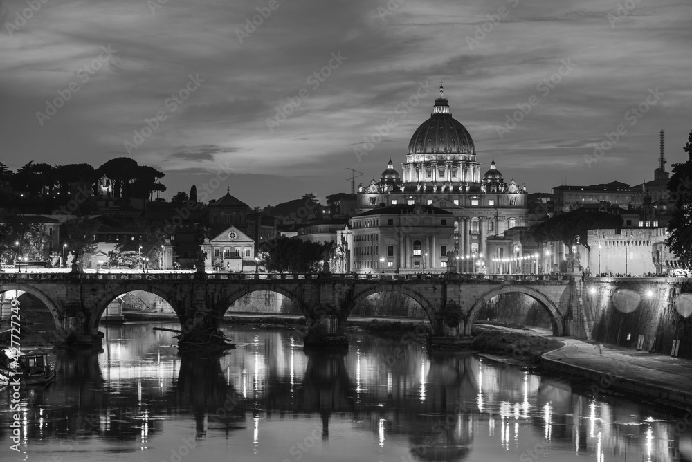 A black and white evening view of St. Peter's Basilica, Vatican City, Holy See, from a bridge over the Tiber river, Rome, Italy	
