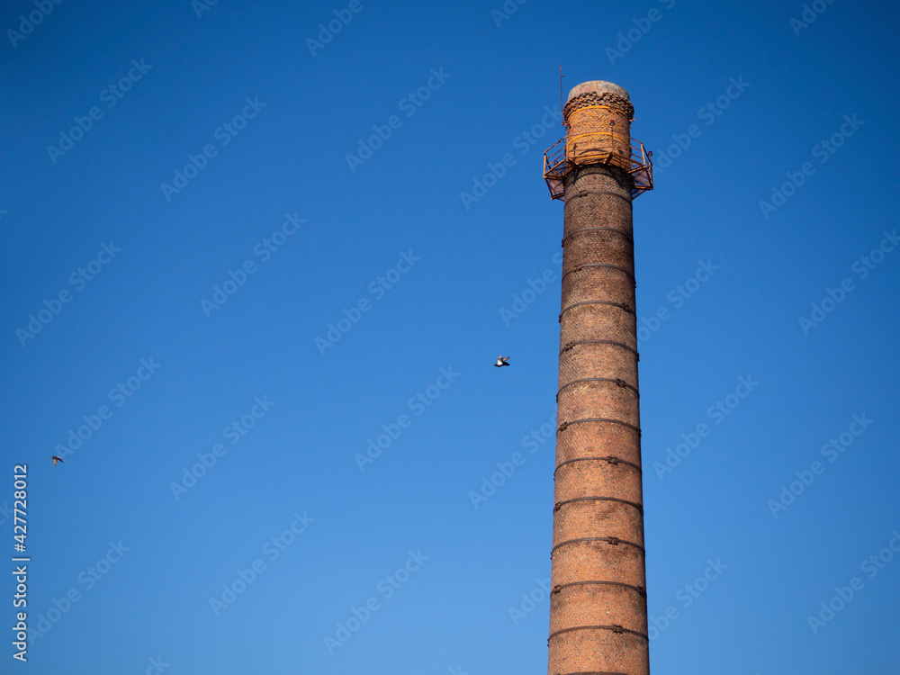 An old industrial chimney against a blue sky.