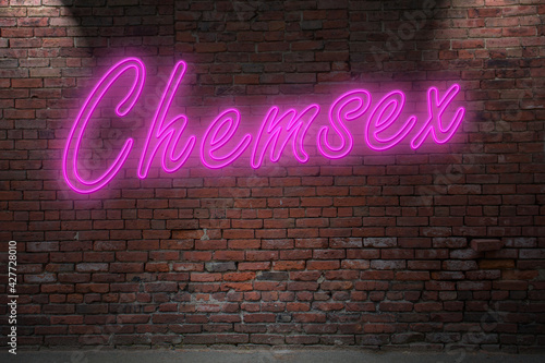 Neon BDSM Chemsex lettering on Brick Wall at night