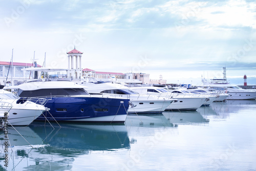 Marina with yachts, small port. Light blue toned image. Beautiful harbor with docked luxury sailing ships. Moored sailboats in sea bay