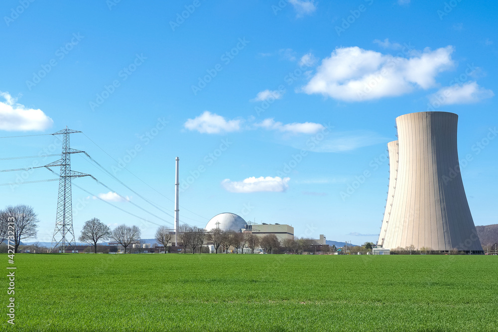nuclear power plant against sky and green grass