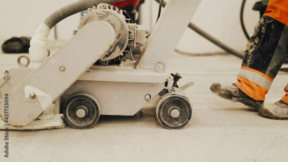 Workers grind the concrete floor at the construction site. Workers grind the concrete floor at the construction site.