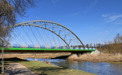 Green and gray steel bridge over the Suprasl River. White and blue railings photo