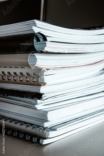 Stack of reports lies on a desk ready for review