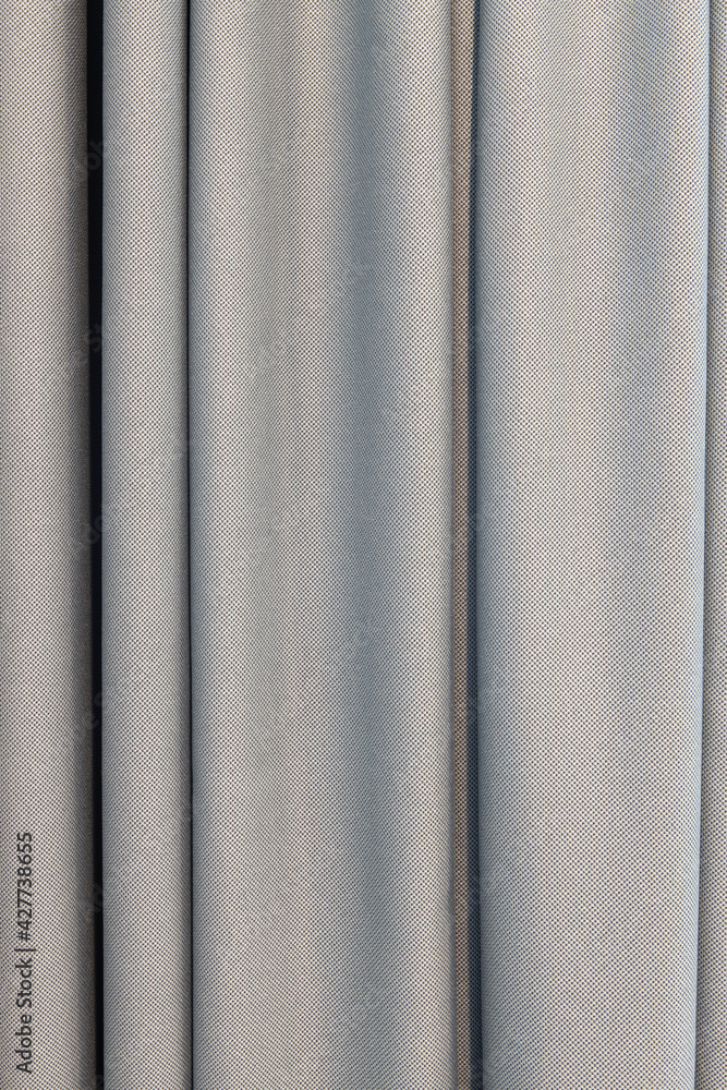 Fototapeta premium Gray curtains made of natural silky fabric, with large folds, close-up. Concept details of a modern stylish interior, the use of natural materials in basic universal colors. Vertical