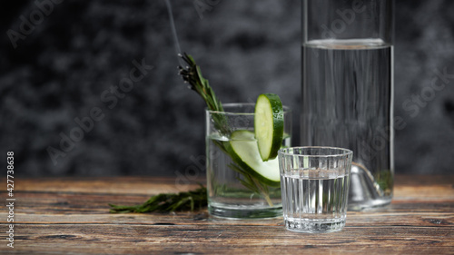 Bebida mexicana de agave mezcal tipo tequila hecha en oaxaca servida en veladora oaxaqueña sobre mesa de madera rústica acompañada de limón y sal de gusano 